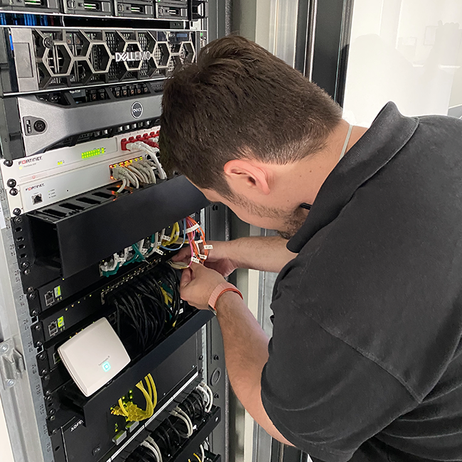 Systemadministrator bei der Arbeit an einem Serverschrank
